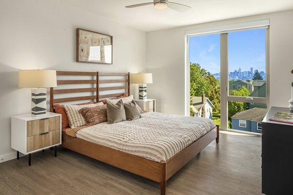 Cozy bedroom with modern decor at Broadstone Vin Apartments, featuring plush bedding and large windows for natural light