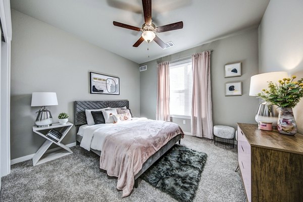Cozy bedroom with large windows and modern decor at The Bend at Highland Meadows Apartments