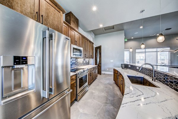 Clubhouse kitchen featuring modern appliances and island seating at The Bend at Highland Meadows Apartments