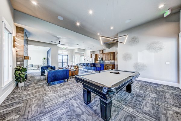 Clubhouse game room with pool table and seating area at The Bend at Highland Meadows Apartments