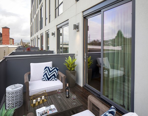 Patio with cozy seating and string lights at The Fitz Apartments, offering luxury outdoor relaxation in an upscale community setting