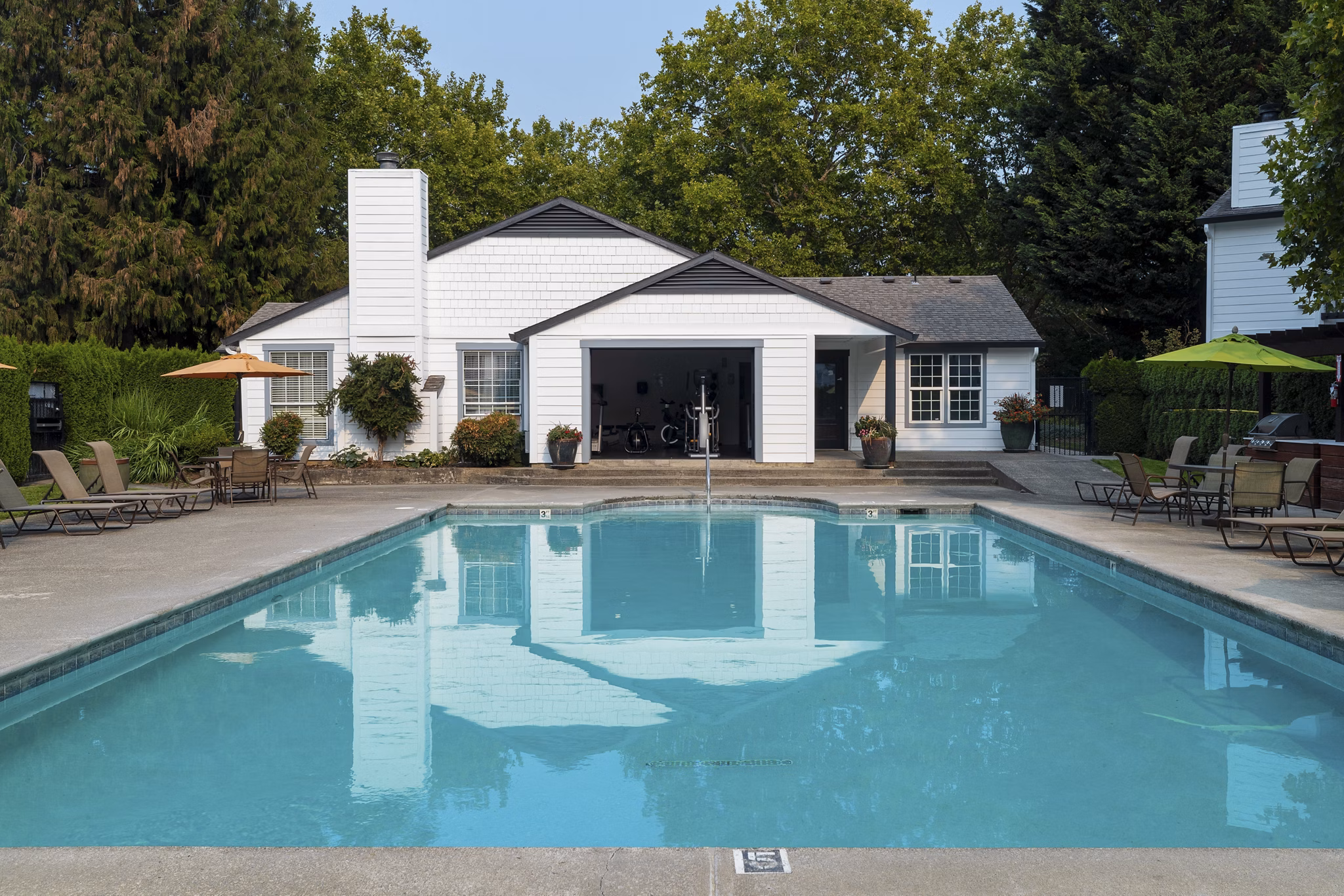Resort-style pool with sun loungers at Sedona at Bridgecreek Apartments, offering relaxation and leisure in a luxury setting