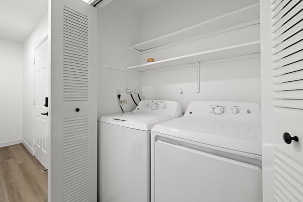 Laundry room featuring modern washers and ample folding space in Silver Oak Apartments