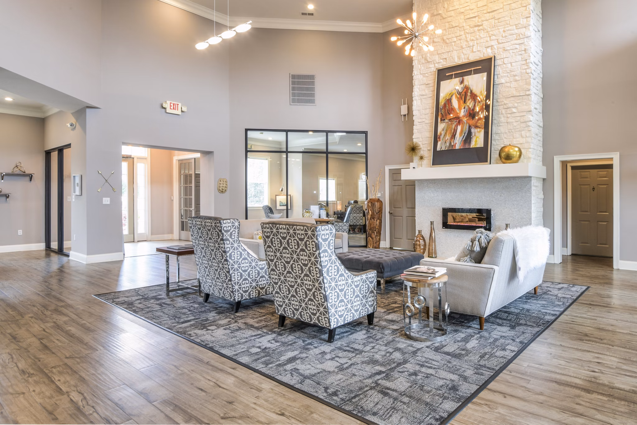 Spacious modern living room with high ceilings, stylish seating, fireplace, and contemporary lighting in luxury apartments