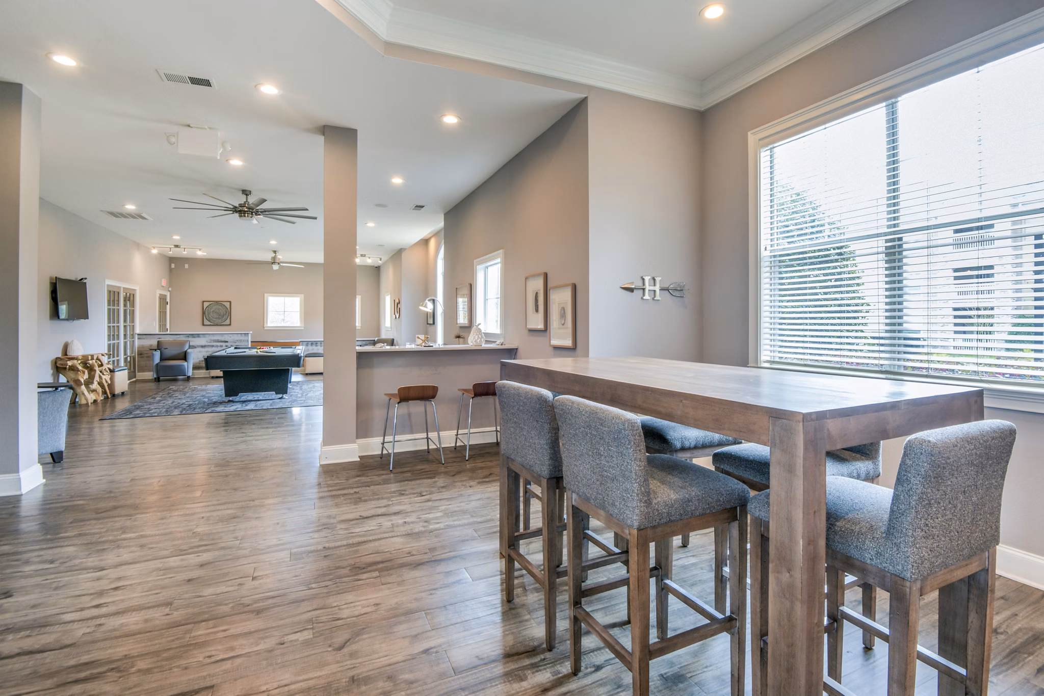 Modern open-concept living space with high ceilings and wooden dining table in luxury apartments