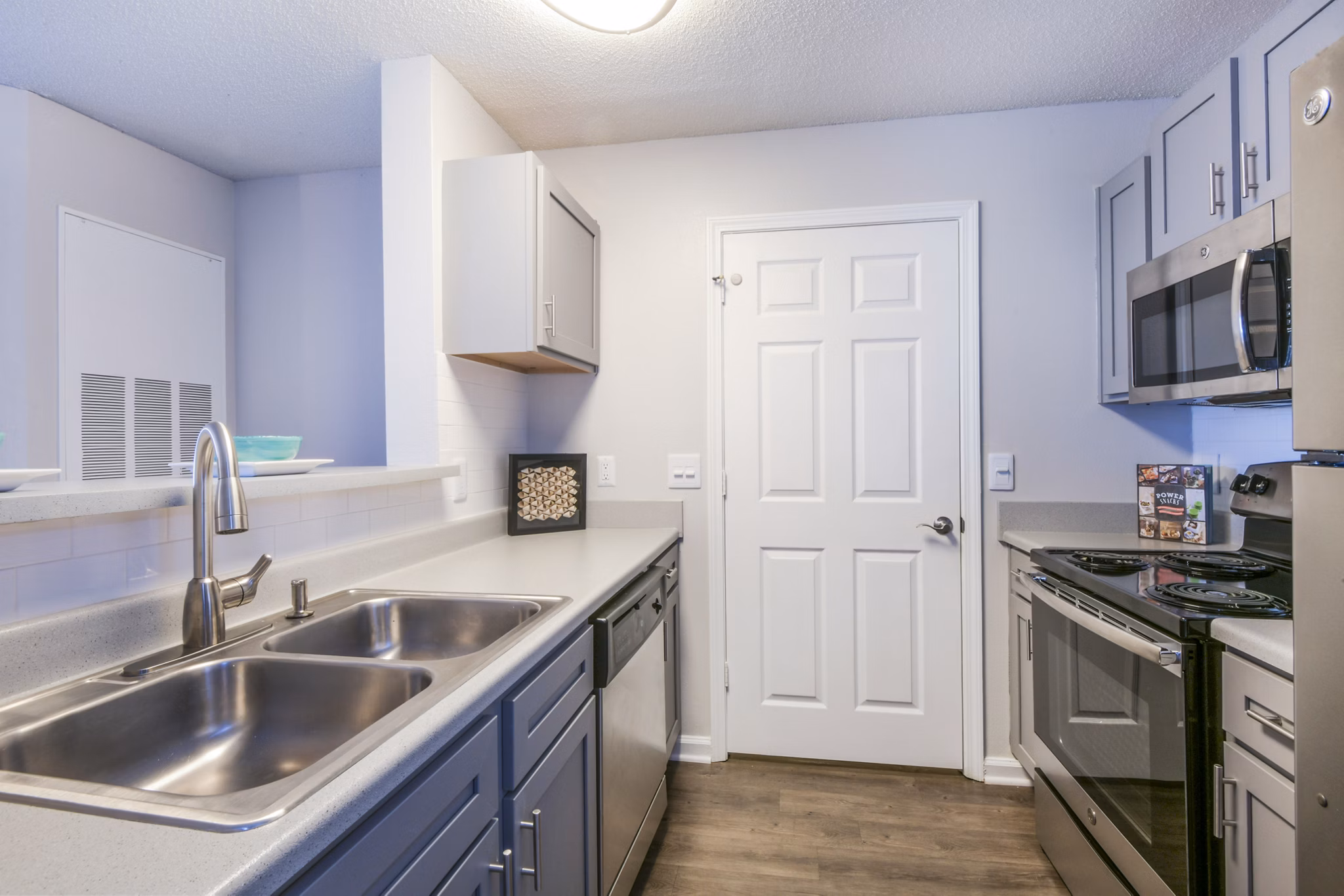 Modern kitchen with stainless steel appliances and gray cabinets in luxury apartments