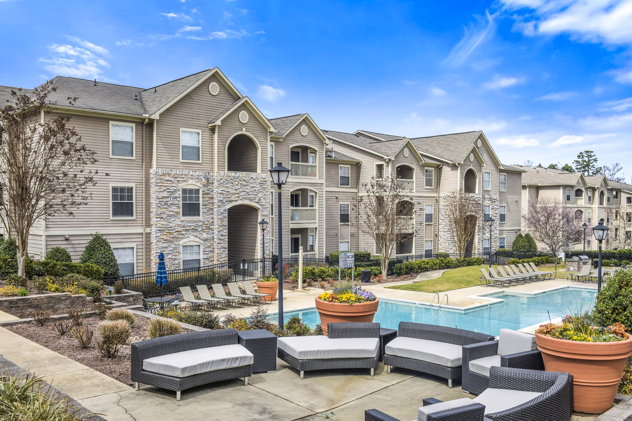Luxury apartments with a swimming pool and outdoor seating in a beautifully landscaped environment