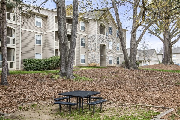 Scenic apartment building with a picnic table surrounded by trees and colorful autumn leaves