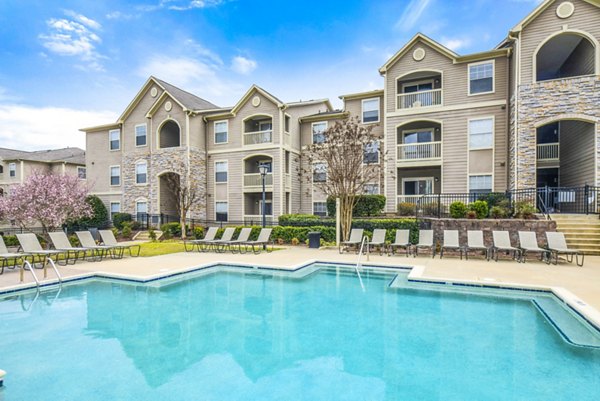 Luxury apartment complex with a refreshing swimming pool in a scenic outdoor setting