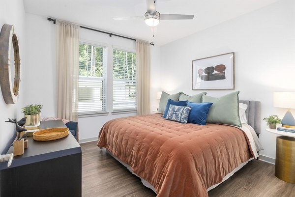 Luxurious bedroom with large windows at Overture Tributary Apartments, a Greystar community offering upscale living spaces