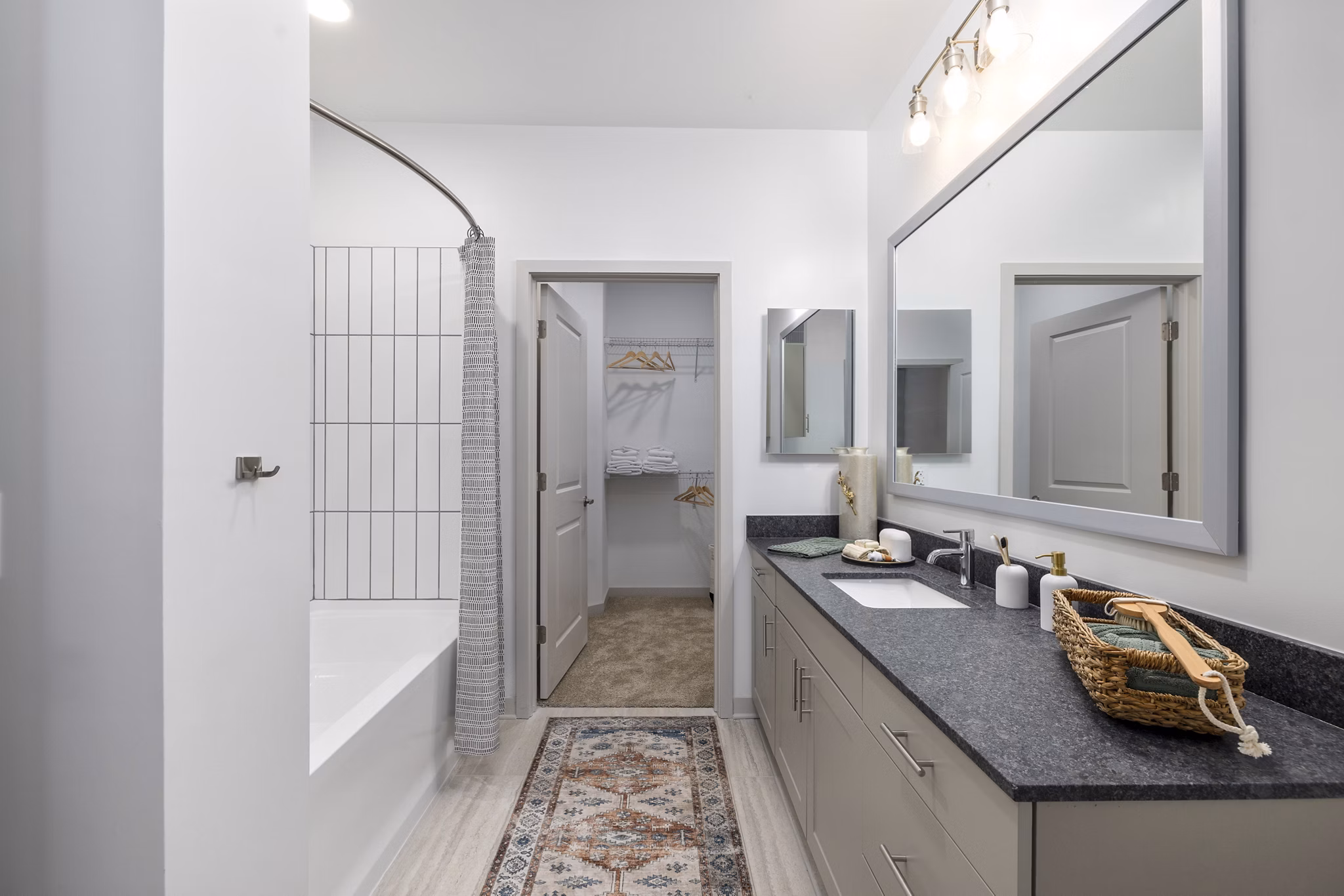 Modern bathroom featuring walk-in shower and double vanity at Overture Tributary Apartments