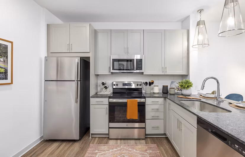Modern kitchen with stainless steel appliances at Overture Tributary Apartments, featuring a sleek design for luxurious cooking and dining experiences