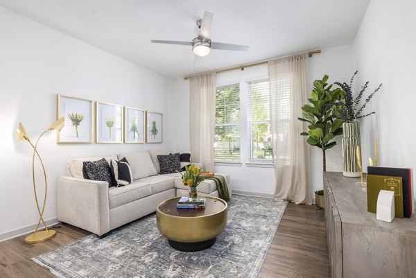 Modern living room with plush seating and natural light at Overture Tributary Apartments for luxury living