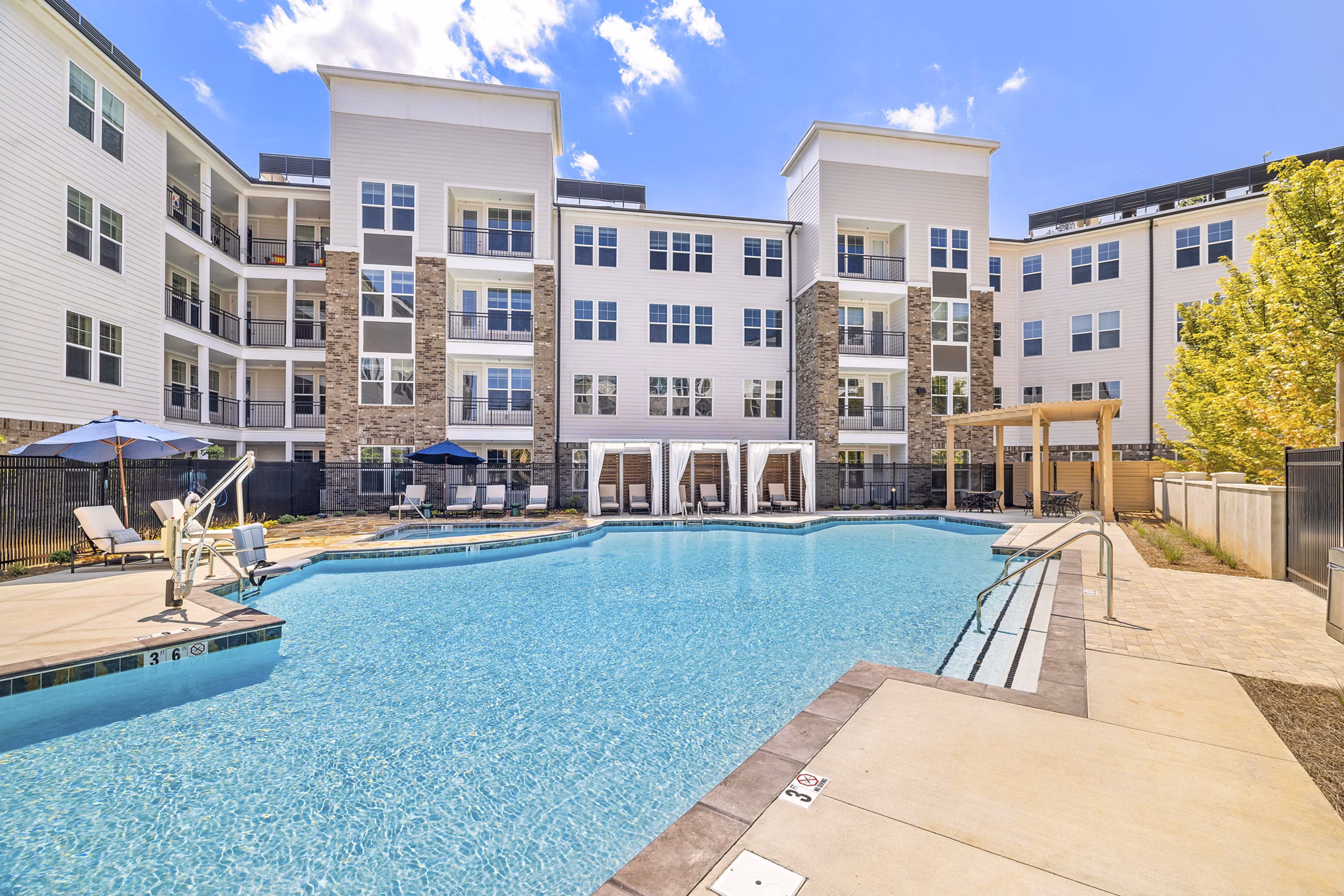 Resort-style pool at Overture Tributary Apartments with lush landscaping and ample lounge chairs