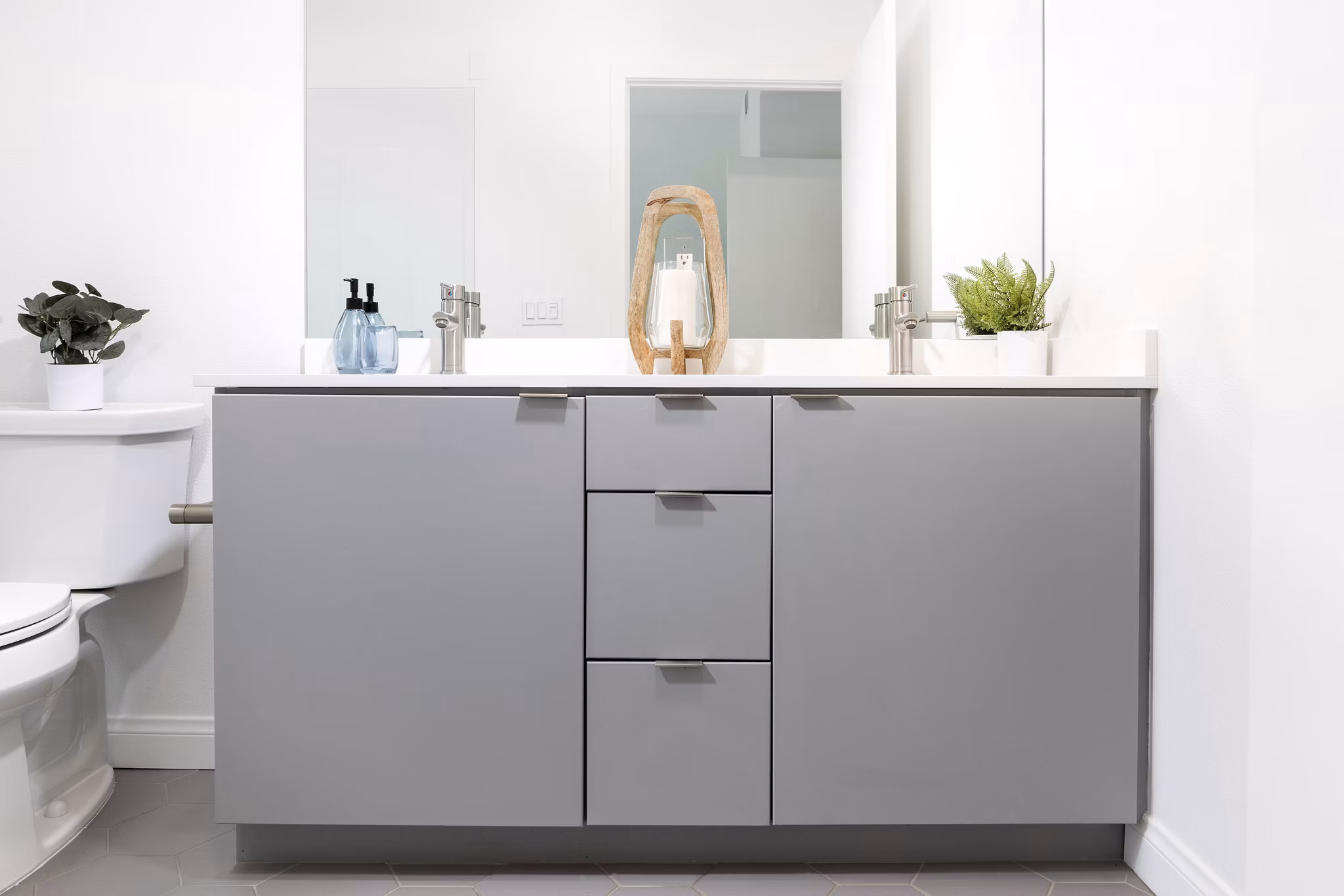 Modern bathroom with marble countertops at The Charlie SM C&B Apartments
