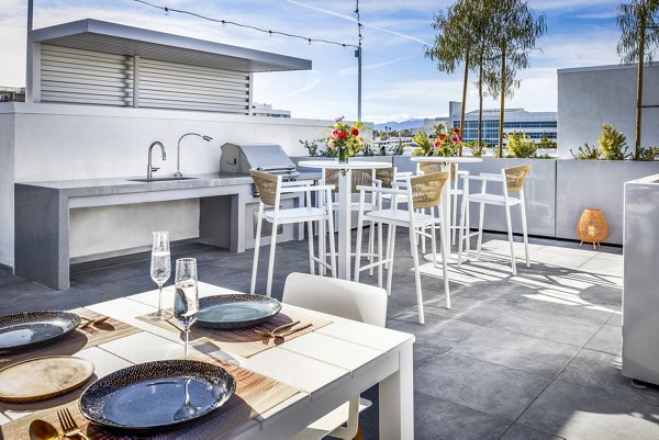 Grill and patio area at The Charlie SM C&B Apartments featuring outdoor seating and modern barbecue station