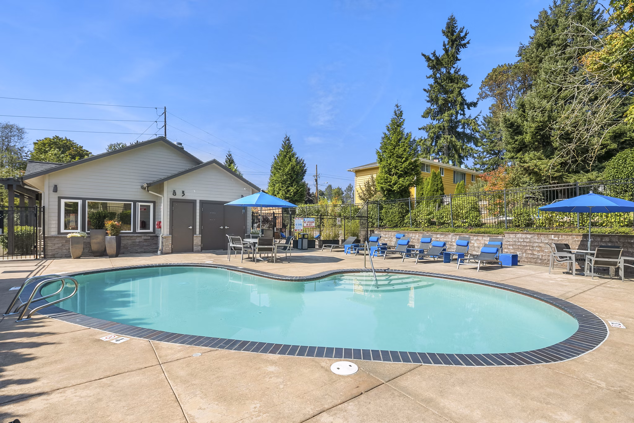 Relaxing pool area at Skyview 3322 Apartments with lounge chairs and lush greenery, ideal for leisure and rejuvenation