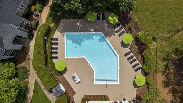 Serene outdoor pool at North Forest Apartments, a Greystar luxury community, featuring lush landscaping and ample lounge seating