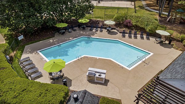 Inviting outdoor pool area at North Forest Apartments featuring relaxing lounge chairs and lush landscaping for luxury living