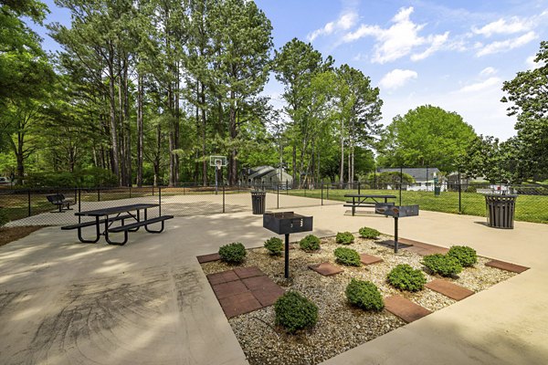 Outdoor grill area with shaded seating at North Forest Apartments