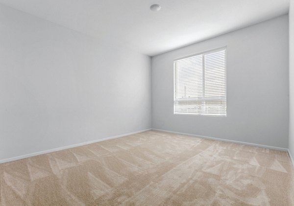 Cozy bedroom with a large window and modern decor at The Element Apartments