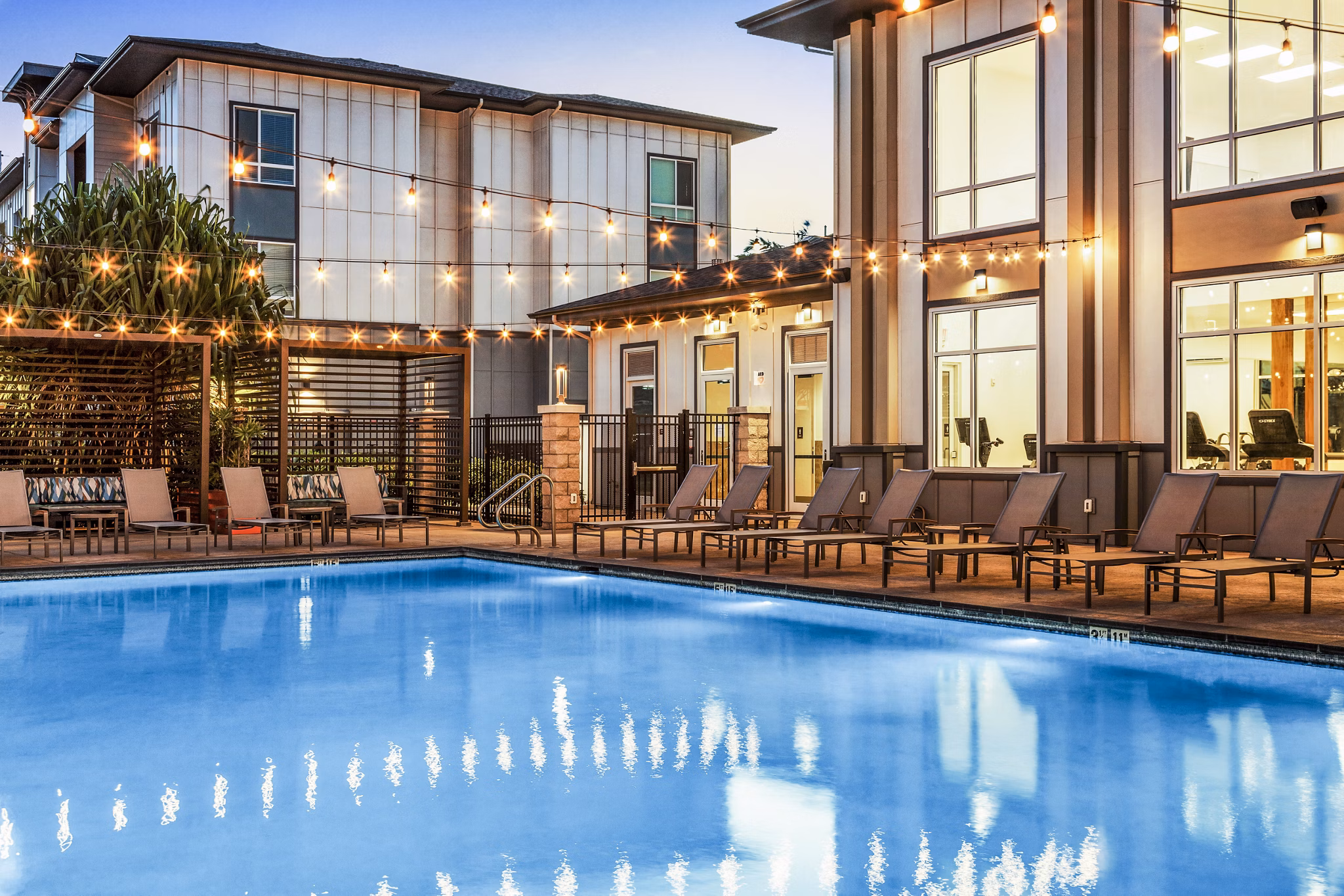 Expansive resort-style pool at The Element Apartments in a lush courtyard setting