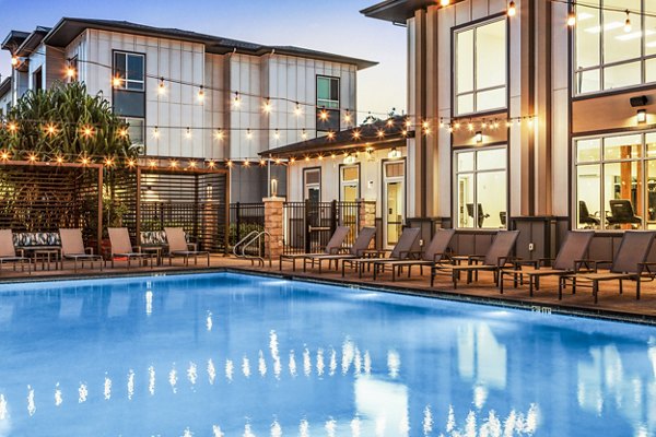 Expansive resort-style pool at The Element Apartments in a lush courtyard setting