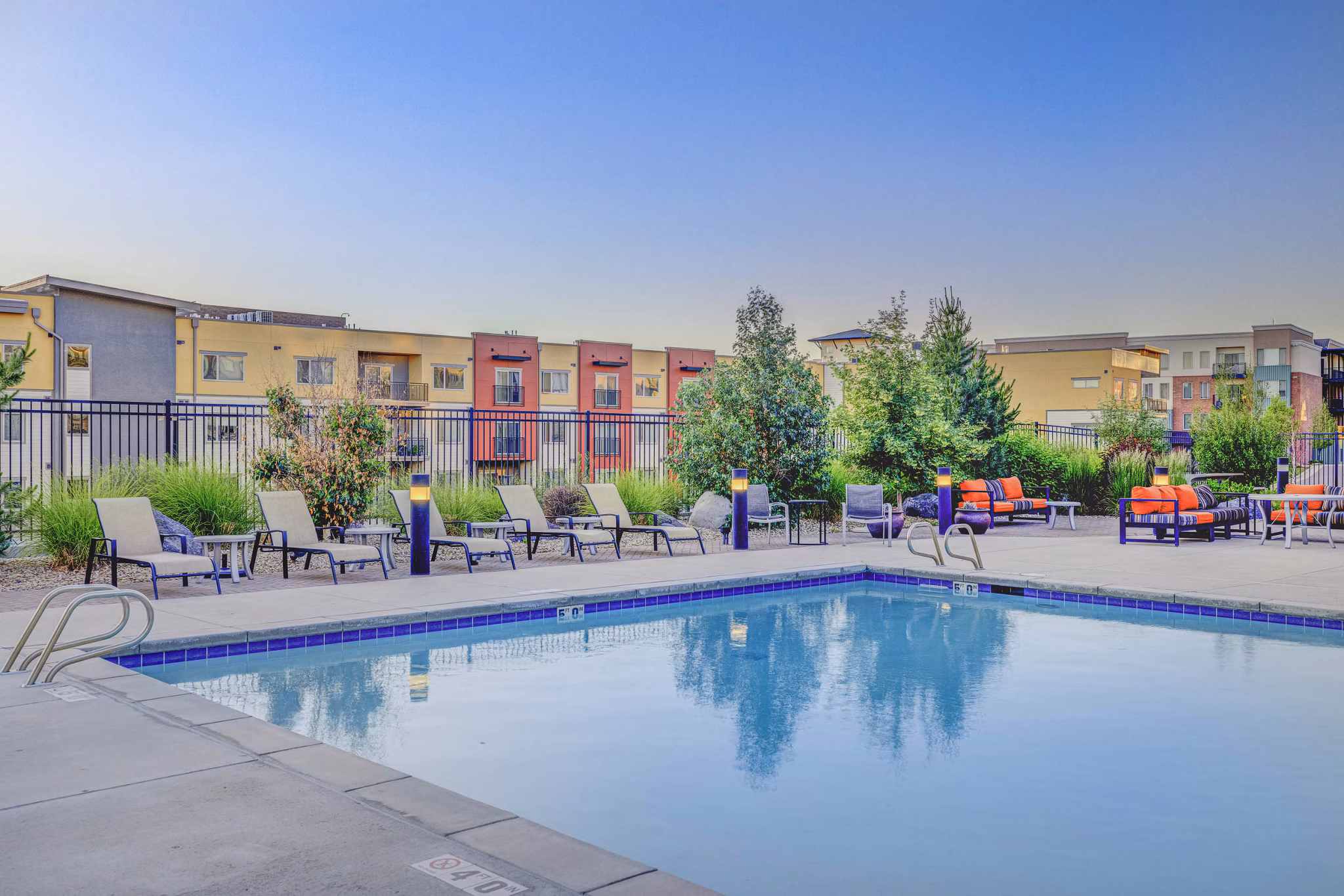 Resort-style pool with lounge chairs at The Calo Apartments luxury community