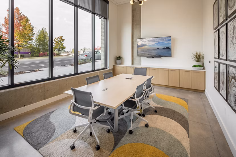 Meeting facility with modern seating and presentation screen at The Overland Apartments