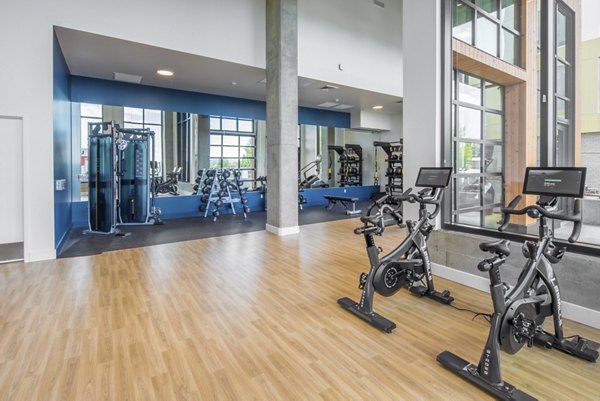 The Overland Apartments: Modern fitness center with cardio machines and free weights for active lifestyle