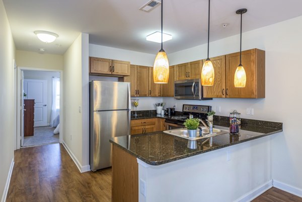 Modern kitchen with stainless steel appliances and granite countertops in Campus View Apartments