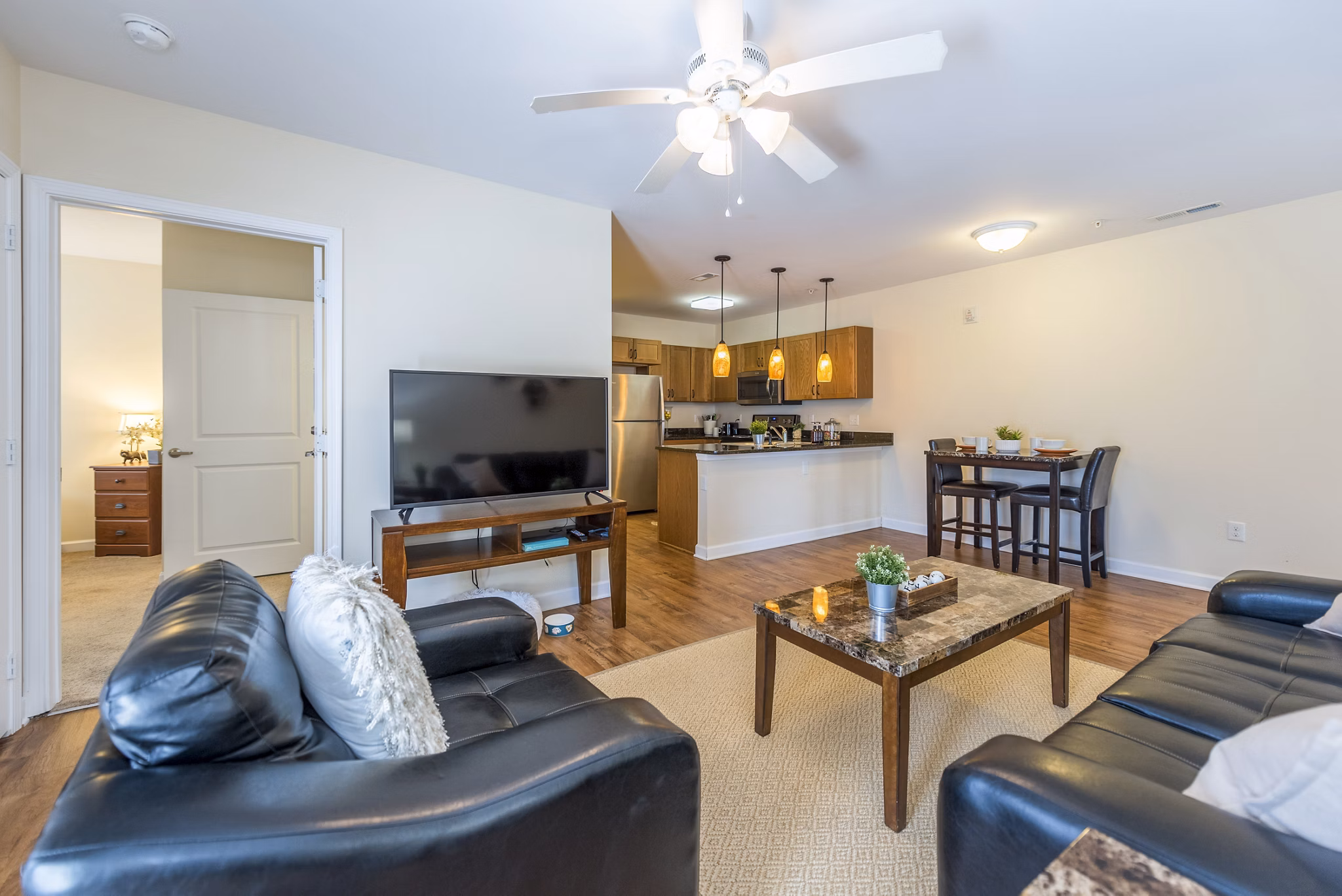 Spacious living room with modern furniture and bright lighting at Campus View Apartments