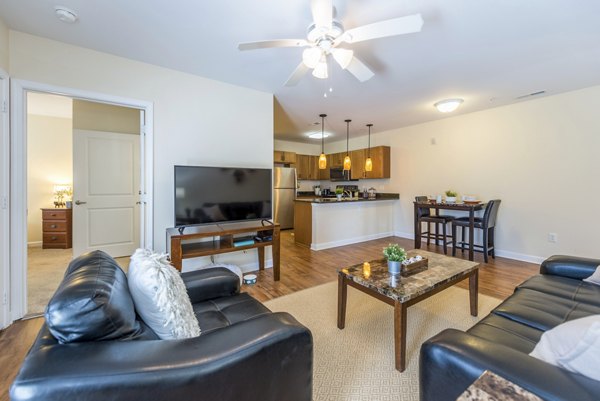 Spacious living room with modern furniture and bright lighting at Campus View Apartments