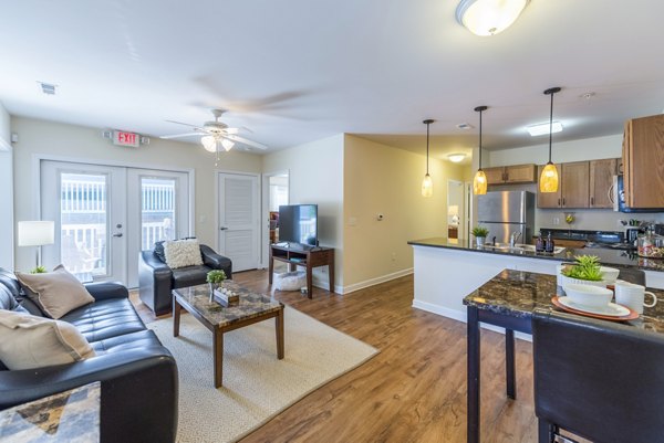 Living room with modern decor and large windows at Campus View Apartments offering comfort and style in a vibrant community setting