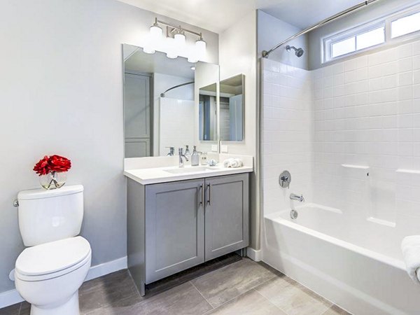 Modern bathroom with marble countertops and glass shower at Sereno Apartments