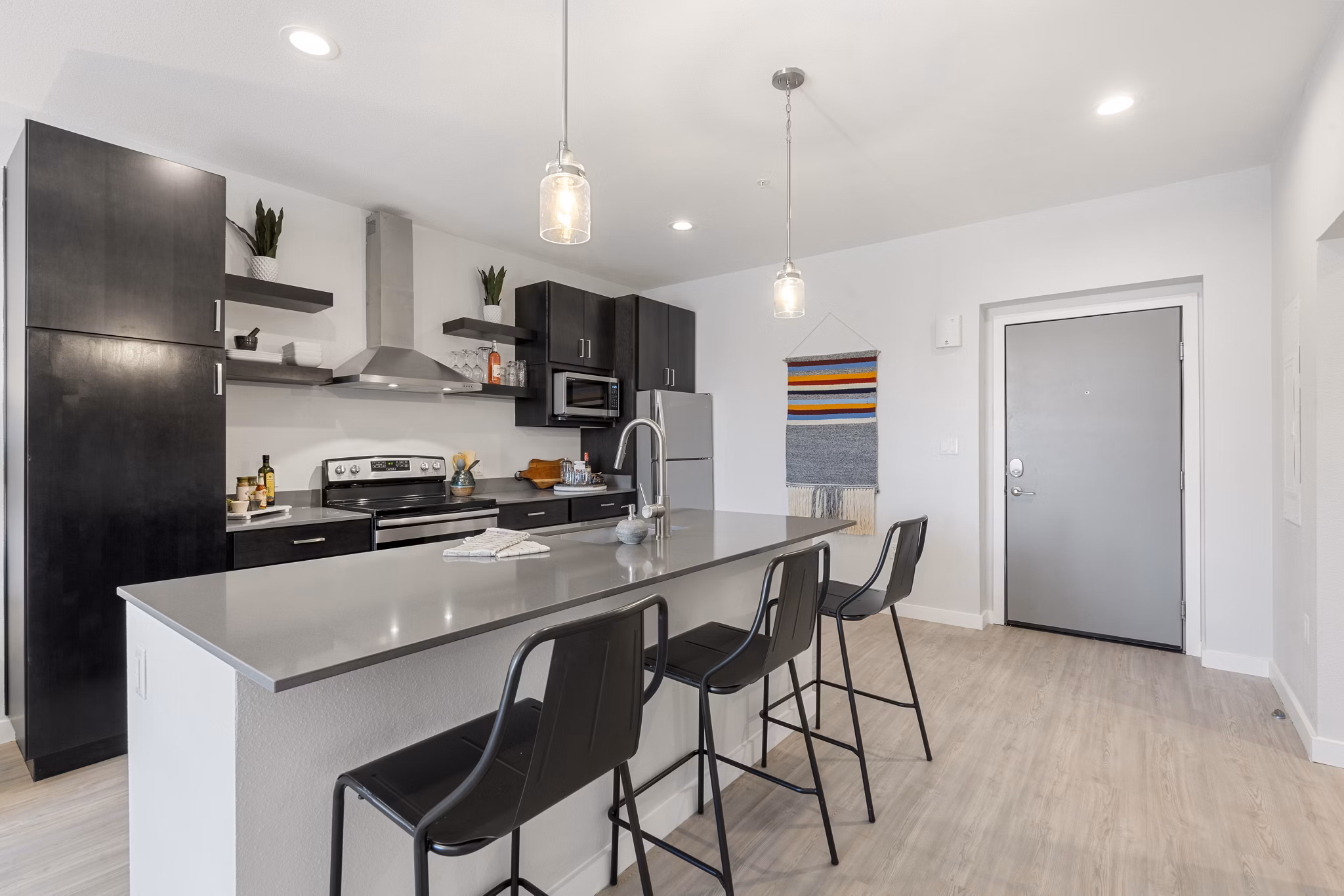 Modern kitchen featuring stainless steel appliances and sleek countertops at FLATZ 602 Apartments, luxury living in an open-concept design