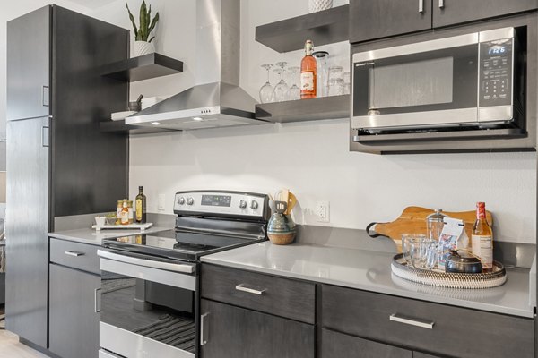 Modern kitchen with stainless steel appliances at FLATZ 602 Apartments