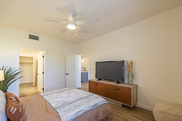 Cozy bedroom with neutral tones and large window at Alma Apartments