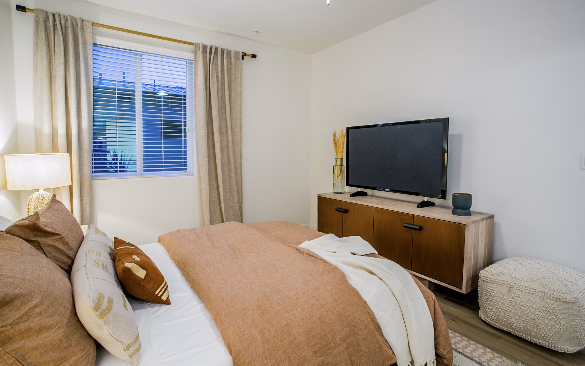 Bedroom featuring contemporary decor and large windows in Alma Apartments, luxury living offered by Greystar