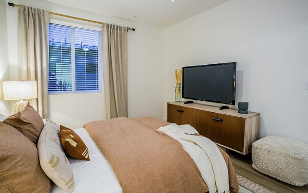 Bedroom featuring contemporary decor and large windows in Alma Apartments, luxury living offered by Greystar