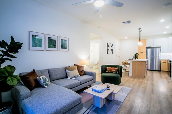 Stylish living room with modern decor and ample natural light at Alma Apartments