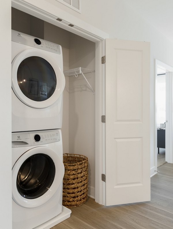 Laundry room with high-efficiency machines at The Cynwyd Apartments, a Greystar luxury community offering modern amenities