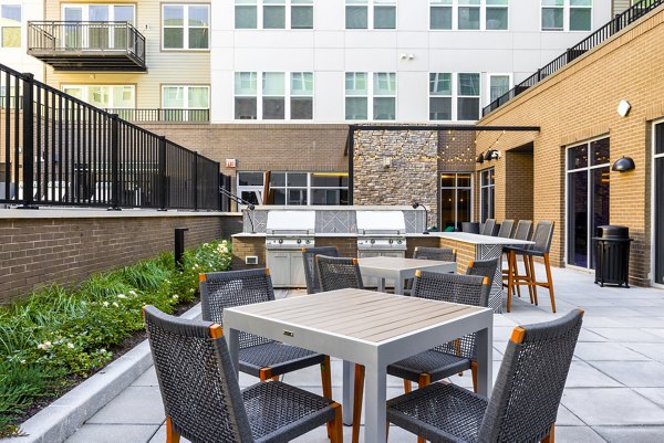 Outdoor grill area with modern seating at The Cynwyd Apartments, perfect for social gatherings and luxury living