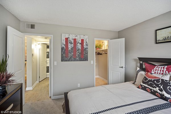 Cozy bedroom with modern decor at Glen at the Park Apartments, featuring luxury furnishings and ample natural light