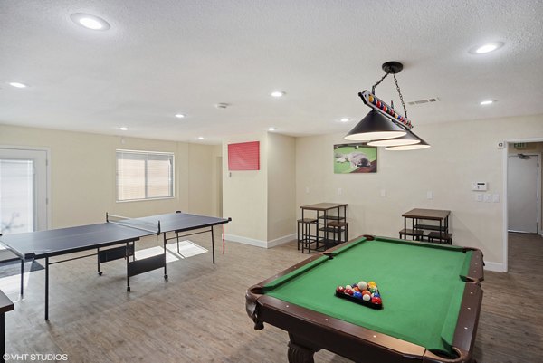 Game room with vibrant seating and pool table at Glen at the Park Apartments, offering entertainment and relaxation for residents