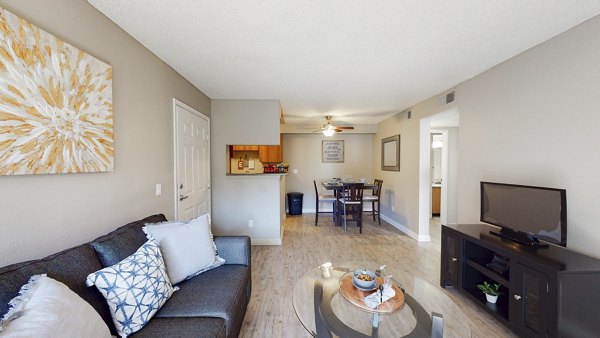 Modern living room with large windows and stylish furnishings at Glen at the Park Apartments