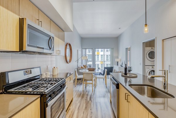 Modern kitchen with stainless steel appliances and island at Arras Apartments