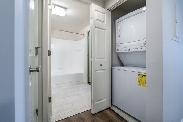 Modern laundry room with high-efficiency machines at The Barton at Woodley Apartments, a Greystar luxury property