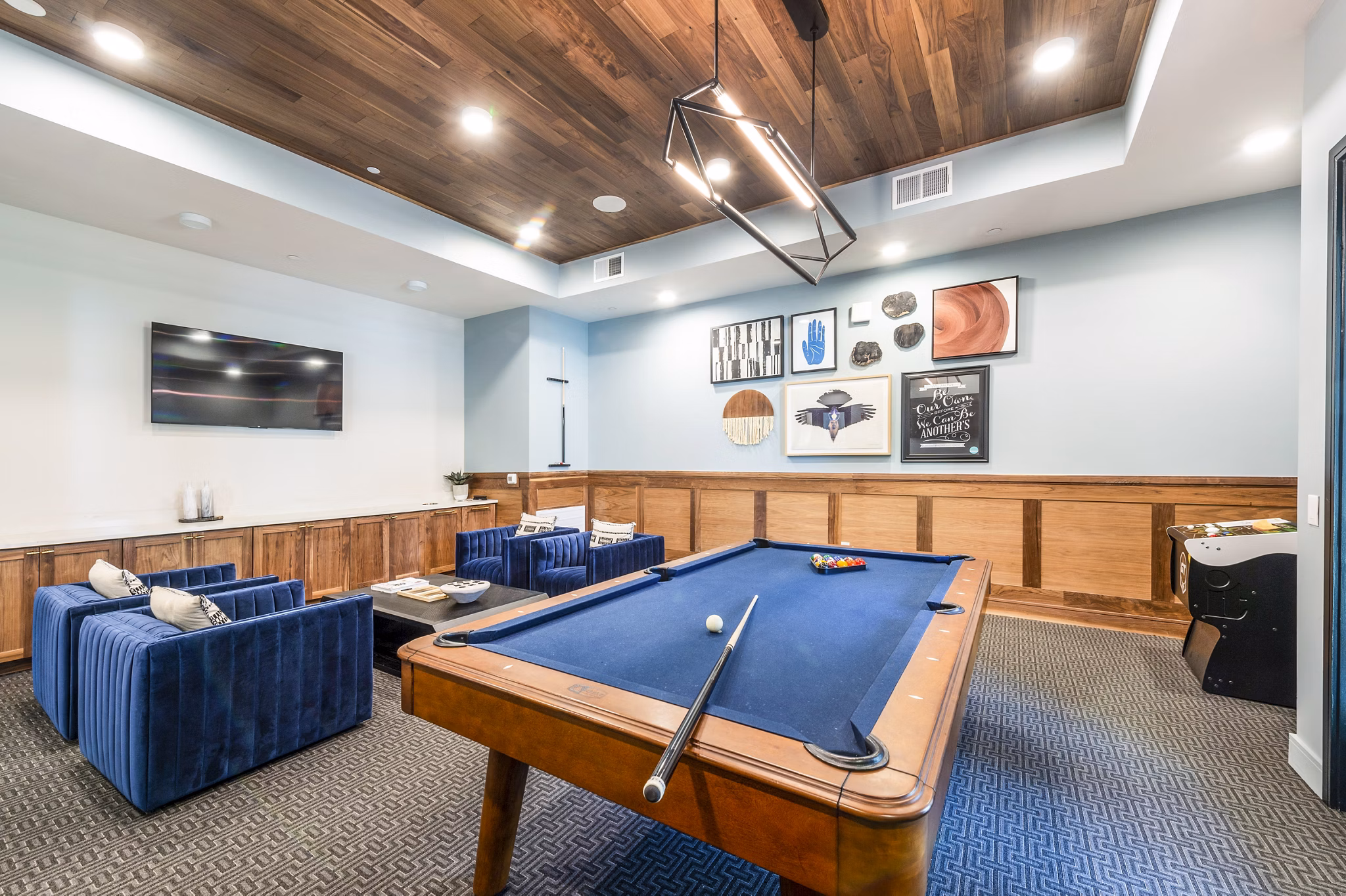 Clubhouse game room with modern seating and pool table at The Waterview Apartments