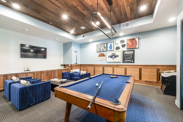 Clubhouse game room with modern seating and pool table at The Waterview Apartments